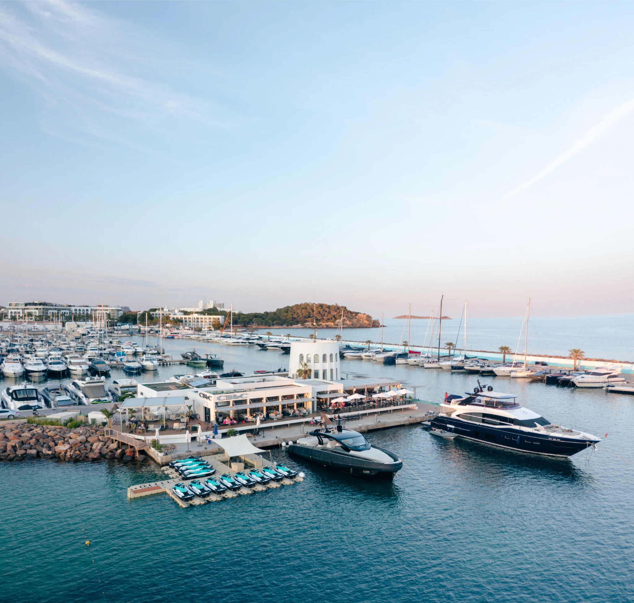 Aerial view of CBBC Marina Santa Eulalia in Ibiza with jetski.club Sea-Doo jet skis and luxury yachts in the marina