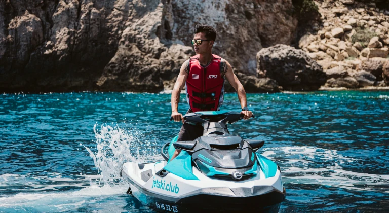 jet-ski-ibiza-rider-jetskiclub Man riding a Sea-Doo jet ski during a guided jet ski tour with jetski.club in Ibiza turquoise Mediterranean waters
