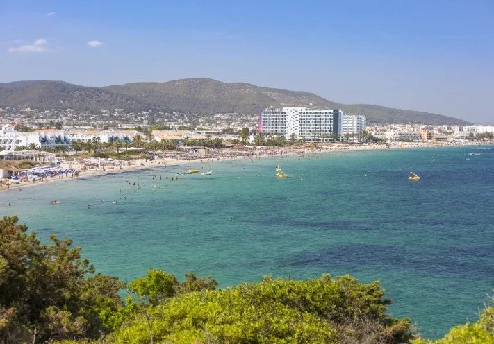 Wide view of Playa d’en Bossa bay Ibiza with jet skis on the water and coastline along the Mediterranean Sea